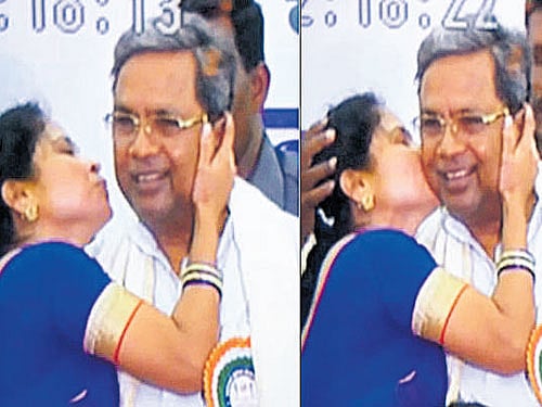 The video grab of a woman kissing Chief Minister Siddaramaiah during an event held at Palace Grounds in Bengaluru on  Sunday. dh photo