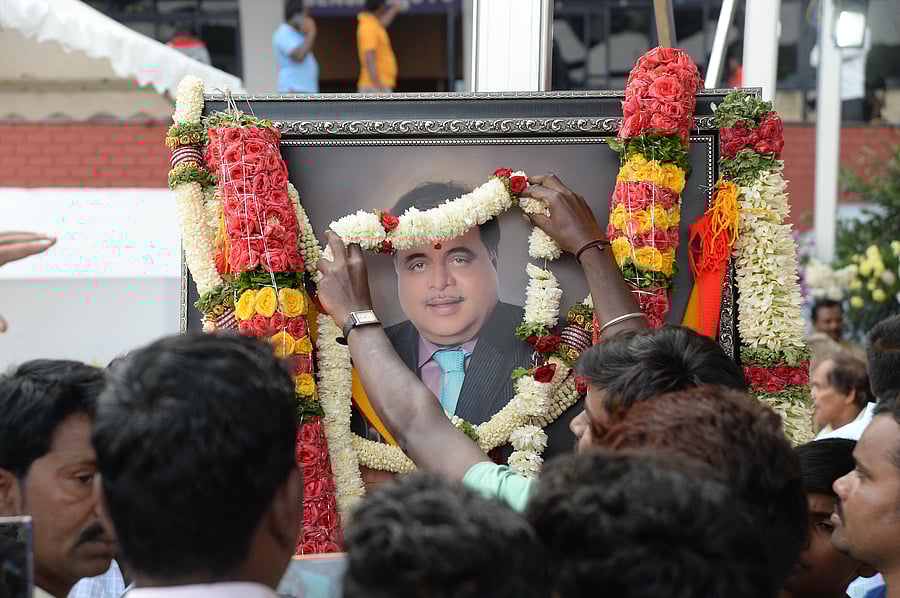 A fan garlands Ambareesh's portrait at the Kanteerava Stadium in Bengaluru on Sunday. (DH Photo/Satish Badiger) 