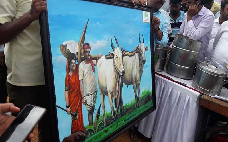 Chief Minister H D Kumaraswamy was presented with artwork depicting him as a framer holding plough, and his wife Anitha Kumaraswamy carrying food, at the paddy field at Sitapur in Mandya district on Saturday. The CM transplanted paddy at a 5-acre field. (DH Photo)