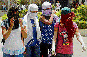 College girls cover their faces to get respite from scorching heat as temperature soars in Gurgaon on Monday. PTI