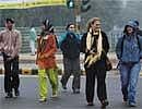 People walk during a cold, foggy morning in New Delhi on Sunday. PTI Photo