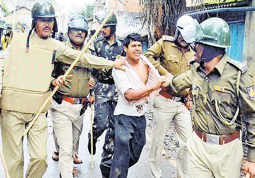 Police take a miscreant into custody at Yellur in Belgaum taluk on Sunday. DH Photo