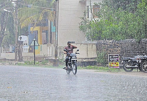 A motorcyclist braves the rain in Gadag on Monday. Dh Photo