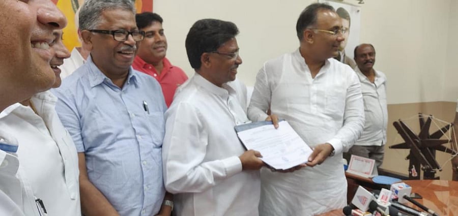 V S Ugrappa with KPCC president Dinesh Gundu Rao in Bengaluru, on Monday. DH photo.