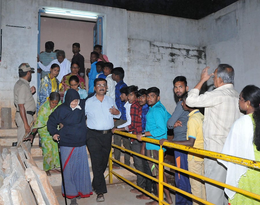 Devotees throng to get a glimpse of Shivakumar Swami, through a window at the Siddaganga Mutt, here on Wednesday. DH photo