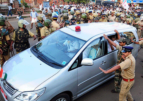 Police try to protect Kerala Chief Minister Oommen Chandy's vehicle during the stone pelt by LDF workers in Kannur on Sunday.PTI Photo