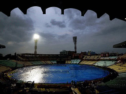 Groundsmen cover the ground as it rains heavily leading to the cancellation of the 1st play off match between KKR and KXIP at Eden Garden in Kolkata on Tuesday. PTI Photo
