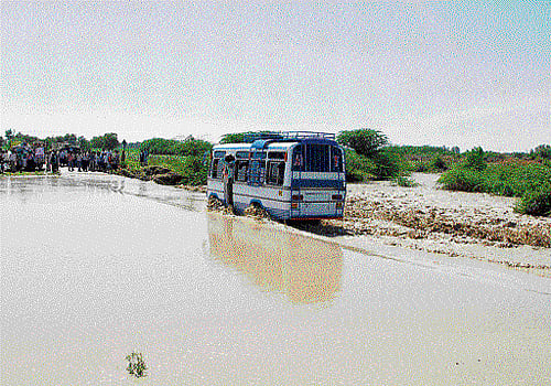 The movement of vehicles was affected at Hiresindogi in Koppal taluk on Wednesday as the road was submerged in the water from Chennihalla pond. DH photo