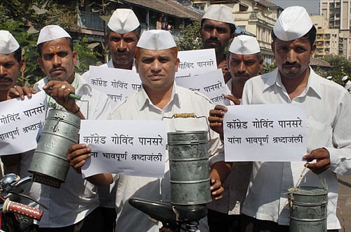 Dabbalawas hold playcards as a tribute to Communist leader Govind Pansare who died yesterday following an attack by unidentified assailants, in Mumbai on Saturday. PTI Photo