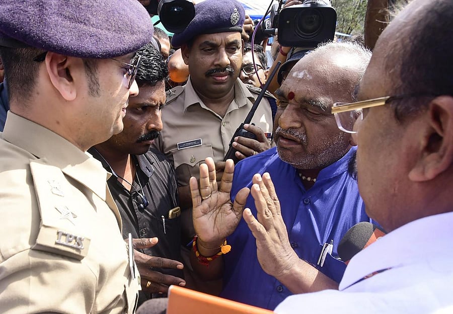 Union Minister of State for Shipping Pon Radhakrishnan talks with a police official at Nilakkal, in Pathanamthitta, Wednesday, Nov. 21, 2018. (PTI Photo) 
