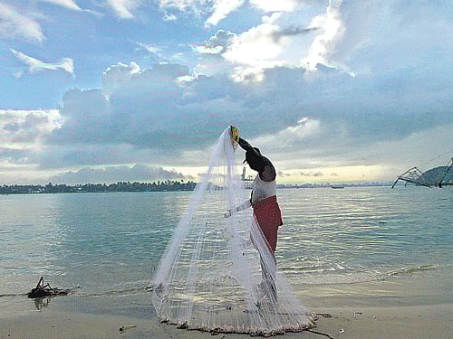 A fisherman arranges his net against the backdrop of pre-monsoon clouds in Kochi on Thursday. Reuters photo