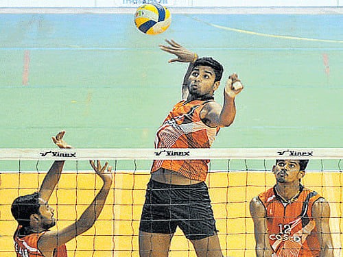 Kerala's Akhin GS attempts to smash past Railways' defence. dh photo