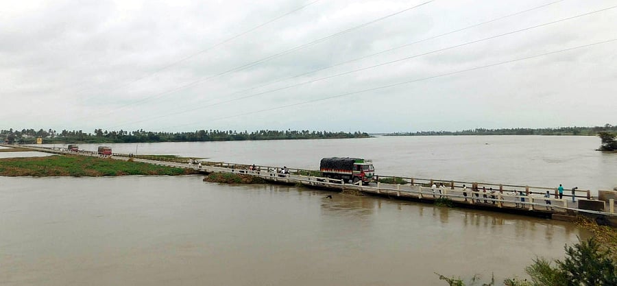 Trucks move on a bridge across a swollen Tungabhadra river near Kampli in Ballari district on Sunday.