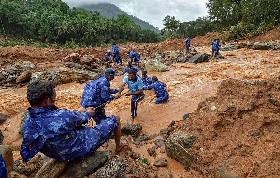 Rescue workers search for the bodies of missing persons after a landslide, triggered by heavy rains and floods, at Nenmara in Palakkad on Friday. PTI