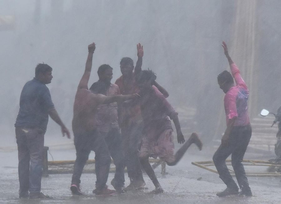 Holi revellers dance in the heavy rain in Hubballi on Monday. (Right) The rain affected the movement of vehicles on Lamington Road in the city. DH Photos/ Tajuddin Azad