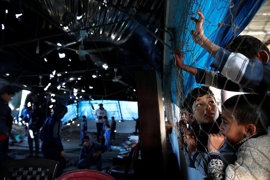 Palestinian boys watch as others inspect a mosque that was damaged in a nearby Israeli air strike in Gaza March 26, 2019. REUTERS