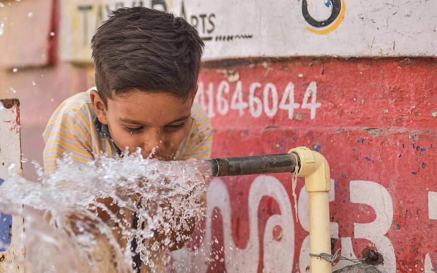 A boy drink water from a bowerwell near SPV Circle in Kalaburagi on Friday. ... To go with Ravi Balutgi story... - Photo/ Prashanth HG
