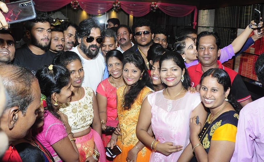 Fans click selfies with actor Suniel Shetty during his visit to Udupi on Friday.