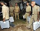 Policemen carry EVMs for the Bihar Assembly elections. PTI
