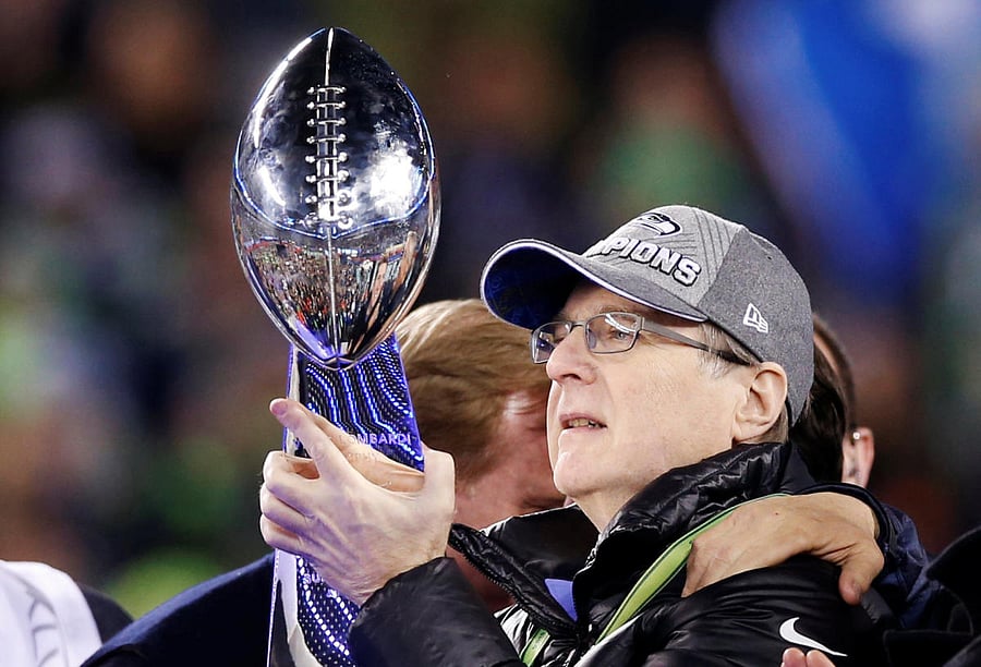 Seattle Seahawks owner Paul Allen holds the Vince Lombardi Trophy next to quarterback Russell Wilson after they defeted the Denver Broncos in the NFL Super Bowl XLVIII football game in East Rutherford, New Jersey, February 2, 2014. REUTERS/Shannon Stapleton/File Photo