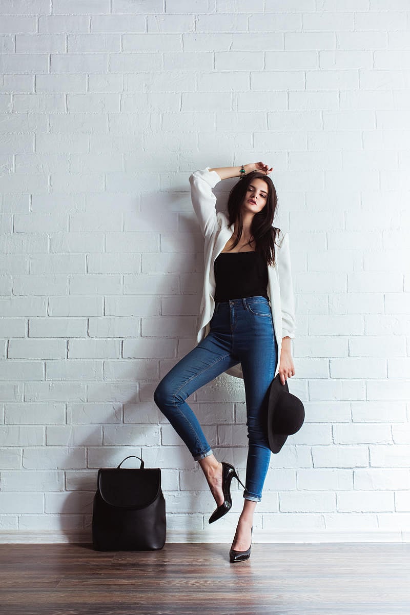 Model, woman in fashionable jeans and a jacket in full length in Studio on a light background