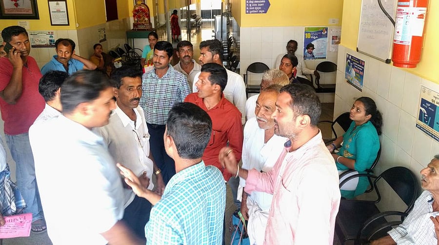 People wait for their turn to register their names under Ayushman Bharat Arogya Karnataka scheme at the Community Health Centre in Kalasa.