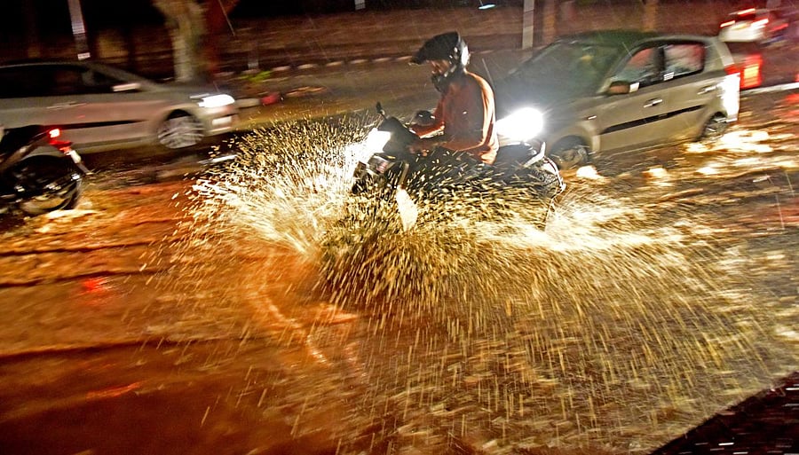 A person drives through an inundated road