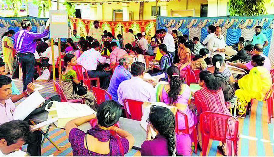 Polling officials verifying the documents pertaining to polling booth at mustering centre, Government PU College, Byndoor.