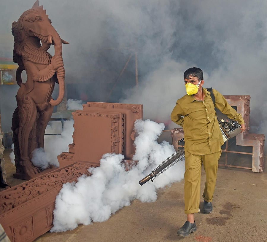 A BMC worker carries out fumigation works at a Ganpati pandal as part of preventive measures against Malaria. PTI