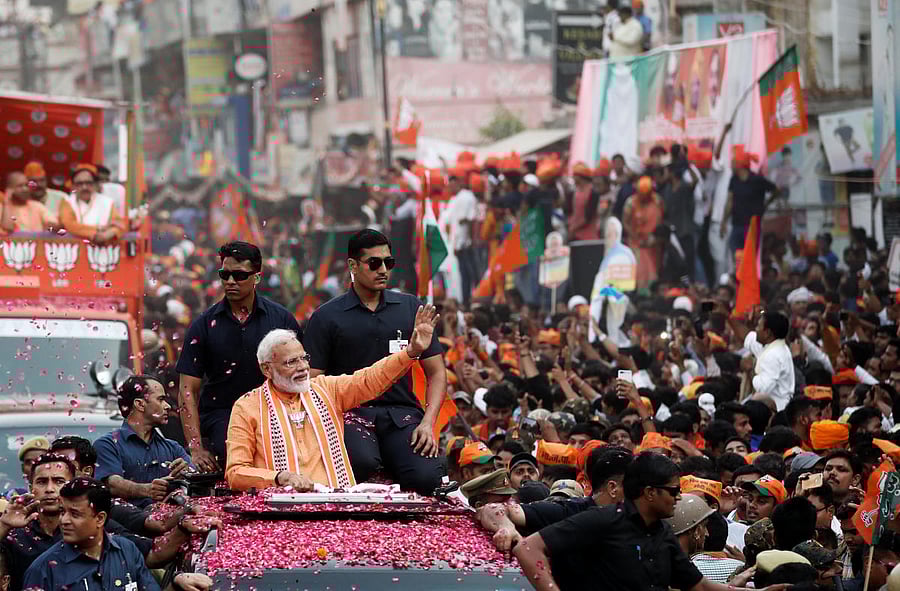 Prime Minister Narendra Modi waves towards his supporters during a roadshow in Varanasi. (Reuters Photo)
