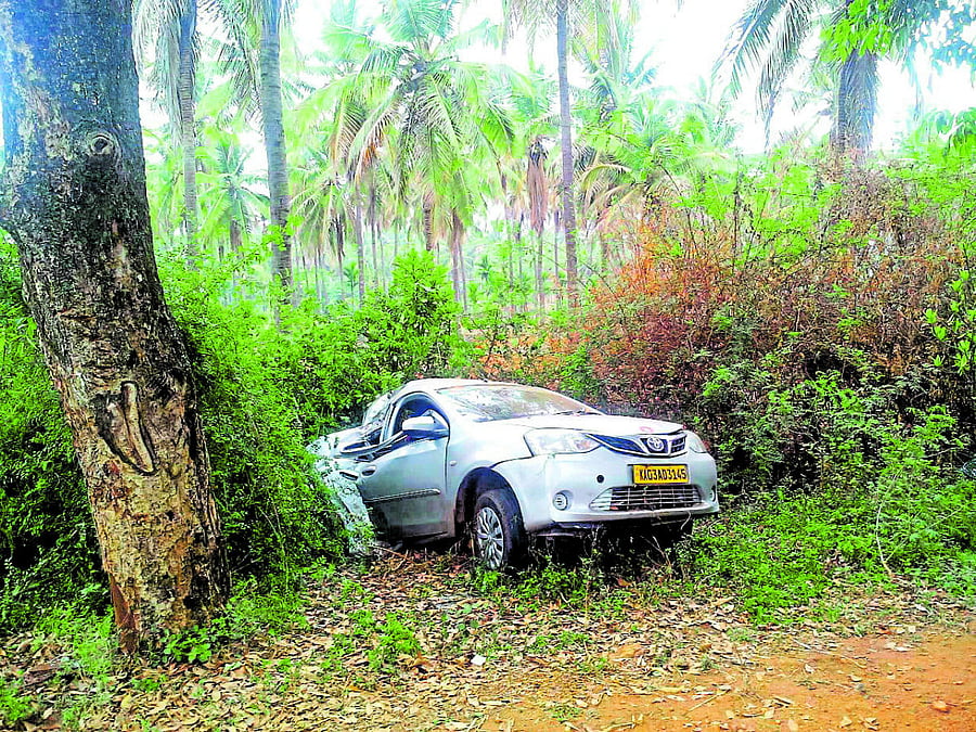 The car that crashed into a rodside tree near KB Cross in Tiputur taluk, Tumakuru district, on Monday.