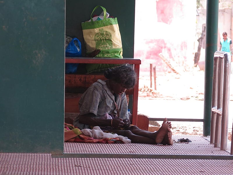 An indigent member of society works outside the gram panchayat building at the village of Kodathi outside Bengaluru. (DH Photo/Akhil Kadidal)