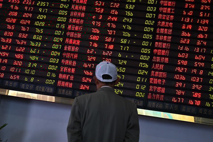 Investors monitor stock price movements at a securities company in Shanghai on May 8, 2019. - A red wave swept across Asia trading floors, as investors grow increasingly concerned that the China-US trade deal, which appeared all by ready to sign, could fa