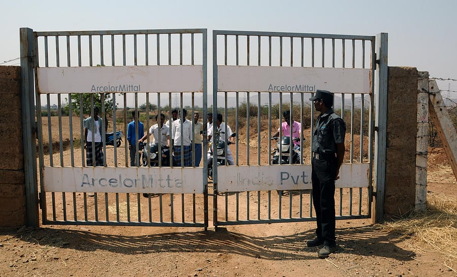 A security guard mans the gate installed by ArcelorMittal on state highway, blocking the traffic between Haraginadoni and Kuditini in Ballari taluk.