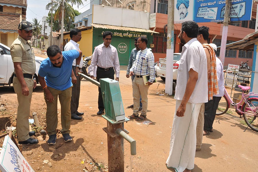 Chikkamagaluru Deputy Commissioner Dr Bagadi Gautam inspects a borewell in Gowrikaluve on Thursday. City Municipal Council K Parameshwar is present.