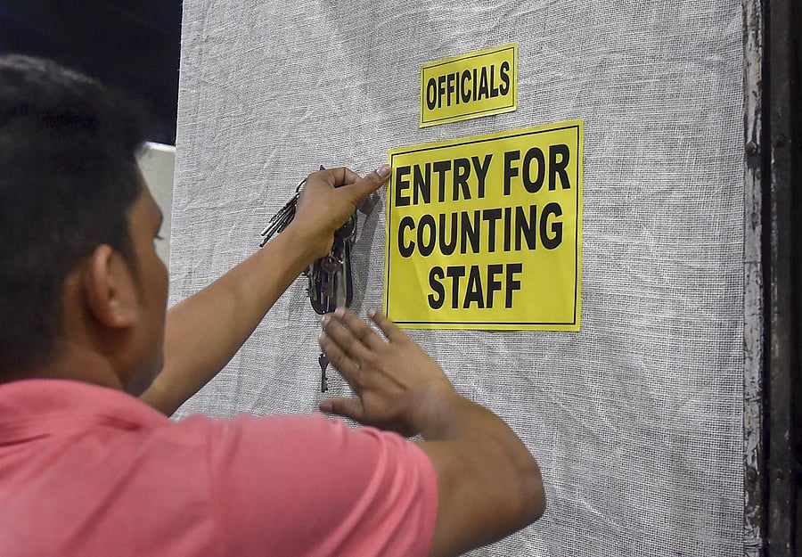  A worker pastes notice on a wall outside a counting centre ahead of the 2019 Lok Sabha elections results, at Netaji Indoor Stadium in Kolkata. PTI photo