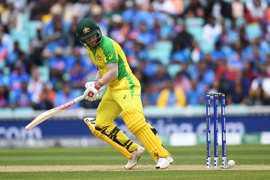 Australia's David Warner looks back as the ball touches his stumps but does not dislodge the bails during their match against India. AFP