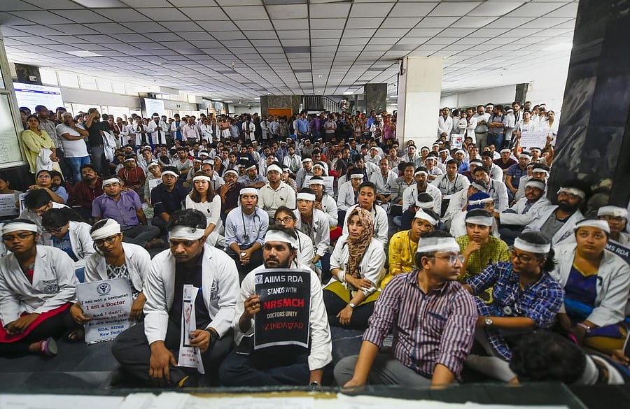 Members of Resident Doctors Association (RDA) of AIIMS wearing bandages on their heads protest to show solidarity with their counterparts in West Bengal, who stopped work on Tuesday protesting against the assault on their colleagues, in New Delhi on Frida