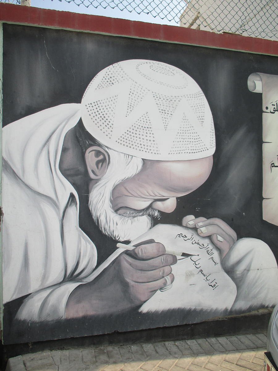 Graffiti on a street wall of a calligrapher at work.