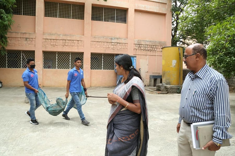 Catchers pass with a nabbed stray dog at a school premise in Austin Town on Wednesday. (DH Photo)