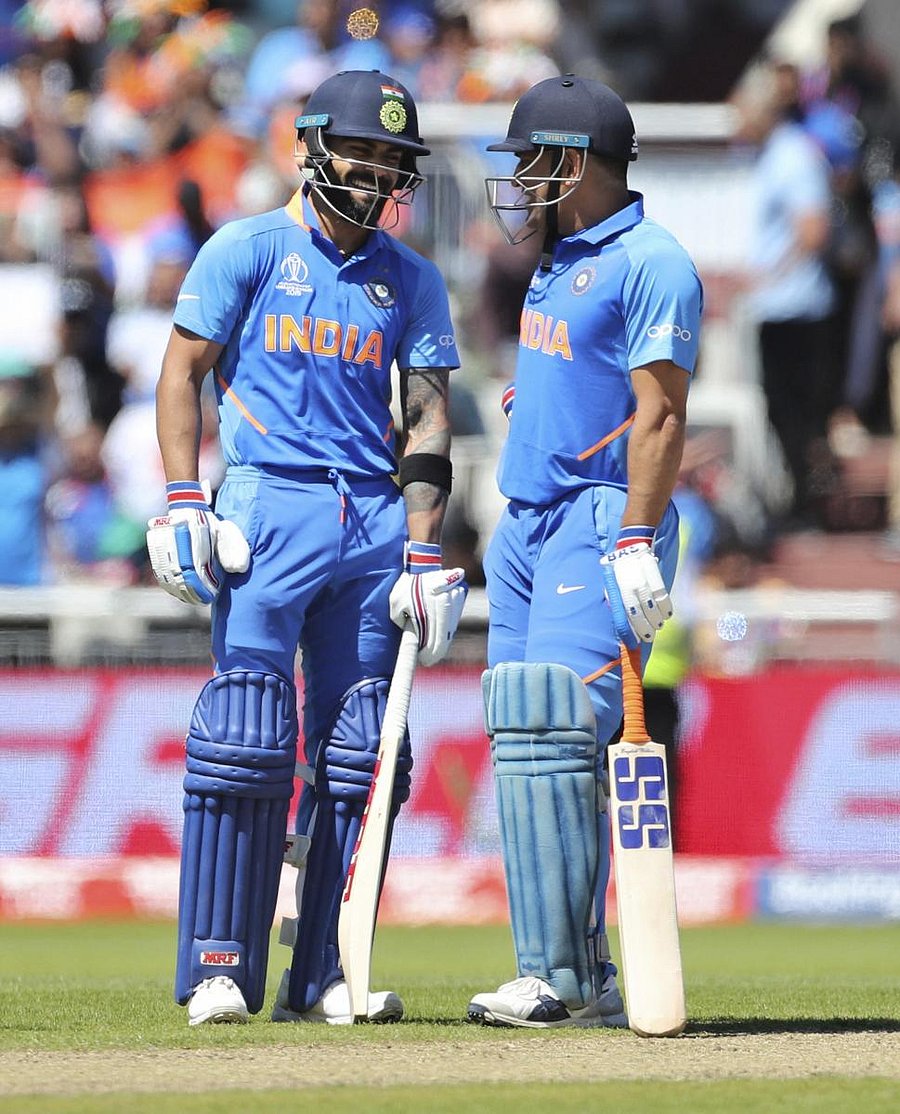 India's captain Virat Kohli, left, and batting partner MS Dhoni share a light moment between the wickets during the Cricket World Cup match between India and West Indies at Old Trafford in Manchester, England. (PTI Photo)