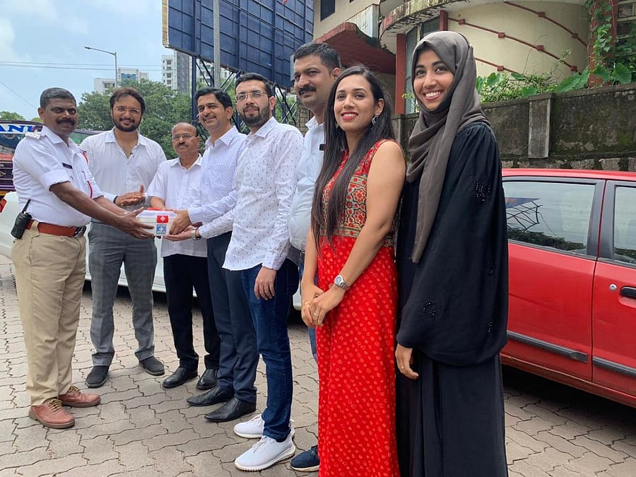 A traffic police officer receives a first aid kit from members of ‘We Are United’ team in Mangaluru on Monday.