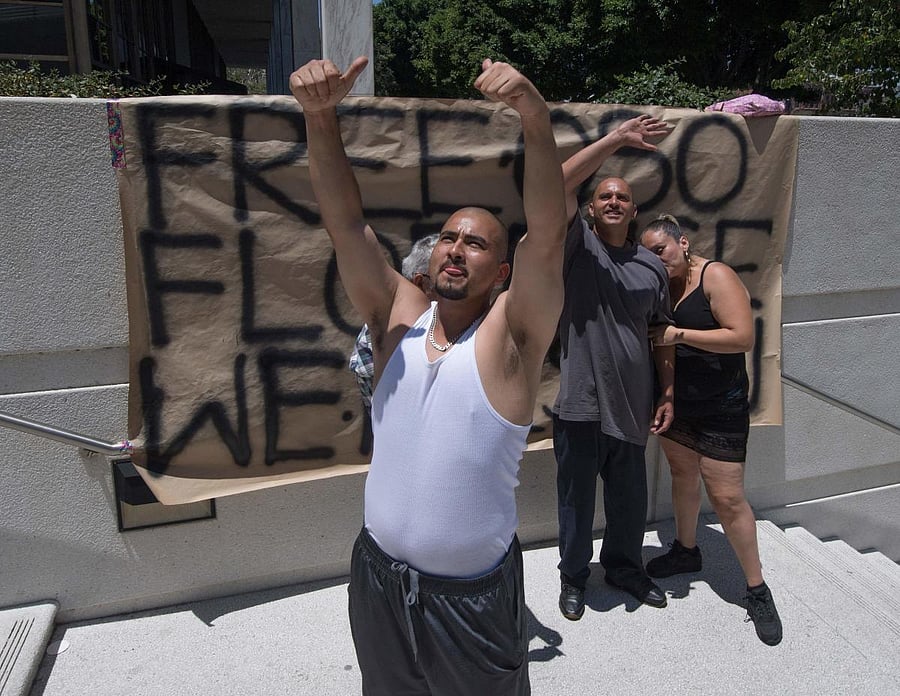 Family members wave to a relative who was picked up in an earlier Immigration and Customs Enforcement (ICE) raid outside the main ICE detention centre in downtown Los Angeles, California on July 14, 2019. - Thousands of undocumented immigrants waited in u