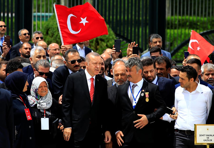 Turkish President Tayyip Erdogan visits a monument as he is flanked by his supporters during a ceremony marking the third anniversary of the attempted coup, at the Presidential Palace in Ankara. (Reuters Photo)