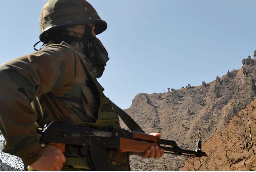 An army jawan keeps vigil after ceasefire violations by Pakistan along the LoC. PTI File Photo