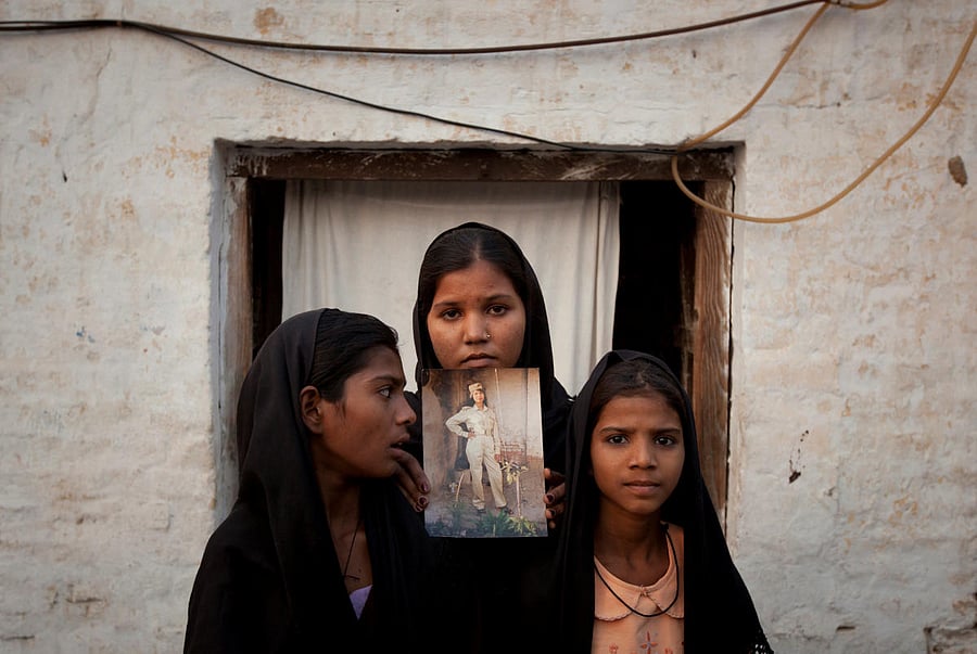 The daughters of Pakistani Christian woman Asia Bibi pose with an image of their mother while standing outside their residence in Sheikhupura located in Pakistan's Punjab Province. Reuters file photo.