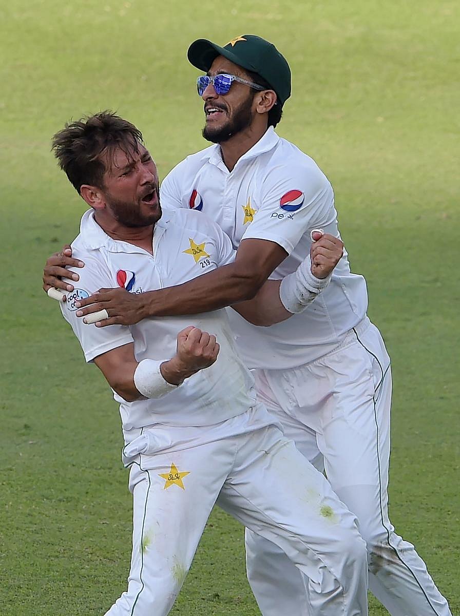 BRILLIANT SHOW! Pakistan's Yasir Shah (left) celebrates with team-mate Hasan Ali after taking the final wicket of New Zealand batsman Trent Boult. AFP