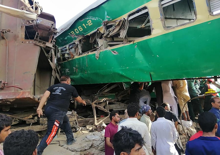 Pakistani rescuers and local residents gather around the wreckage of carriages at the site of train accident in Rahim Yar Khan district in Punjab province (AFP Photo)