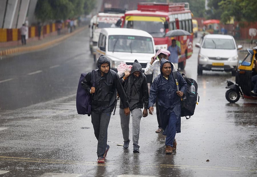 Pedestrians cross a road during heavy monsoon rainfall, in Jammu, Thursday, July 25, 2019. (PTI Photo)