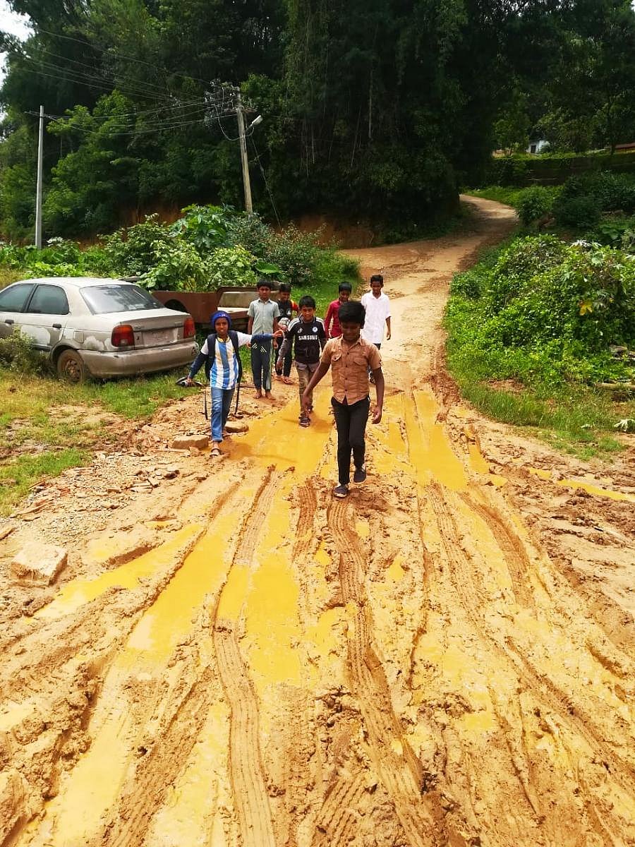 Children walk on the slush filled road leading to Gaddehalla Government Higher Primary School and Boys hostel near Suntikoppa.